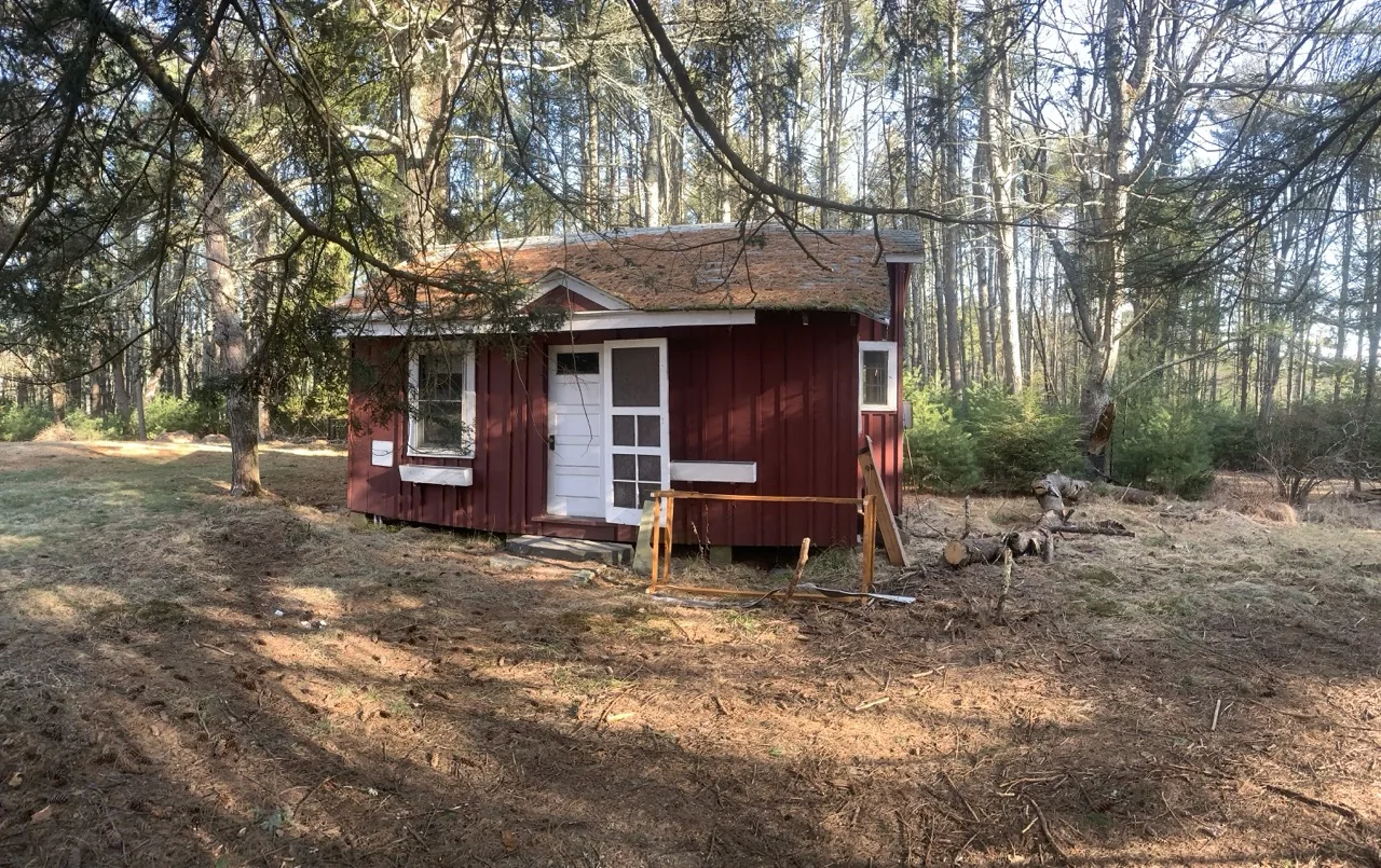 Small red woodland cabin during a restoration project