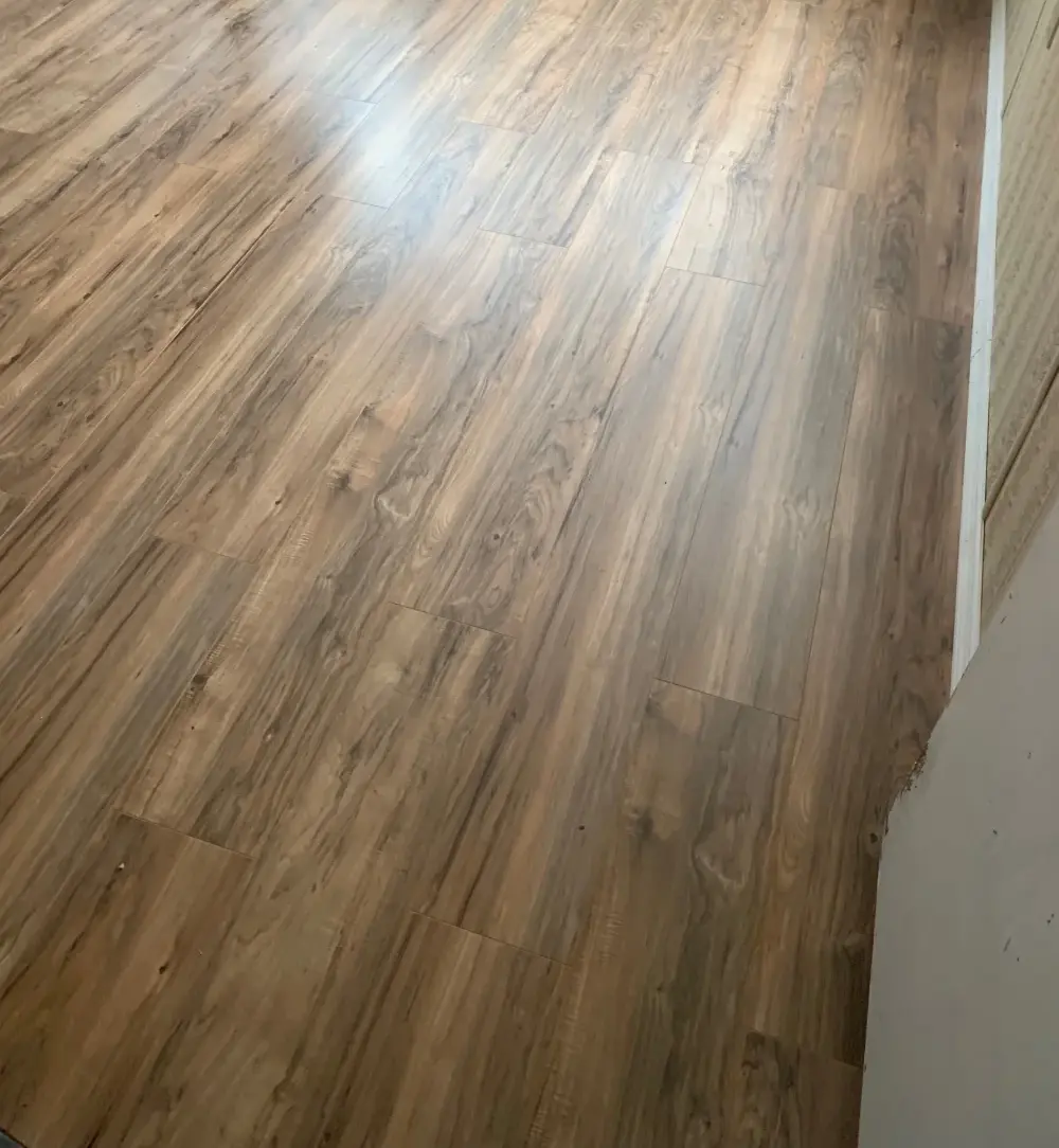 Finished wood-look flooring with bright white base trim