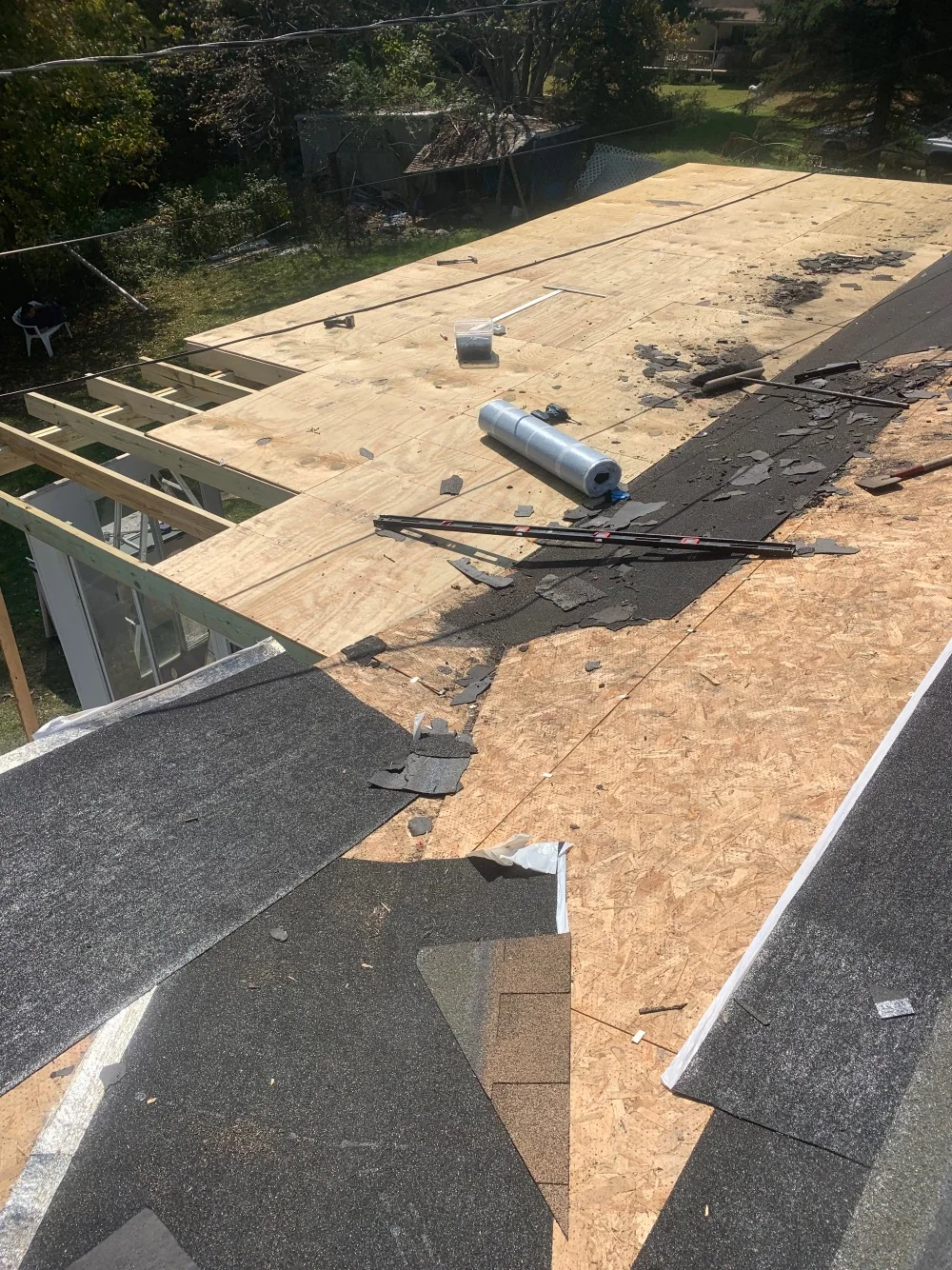 Roof sheathing and shingles during roof work